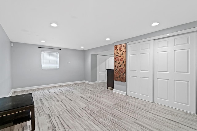 basement with recessed lighting, baseboards, and light wood finished floors