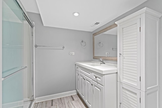 bathroom with vanity, recessed lighting, baseboards, a shower stall, and visible vents