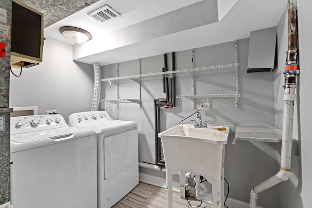 laundry room with independent washer and dryer, laundry area, visible vents, and light wood-type flooring