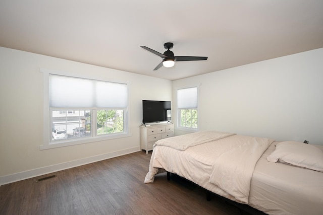 bedroom with baseboards, multiple windows, dark wood-type flooring, and visible vents