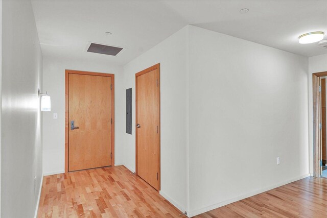 hallway with light wood-type flooring and baseboards