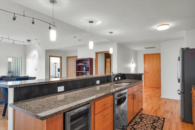 kitchen featuring a sink, wine cooler, open floor plan, appliances with stainless steel finishes, and light wood-style floors