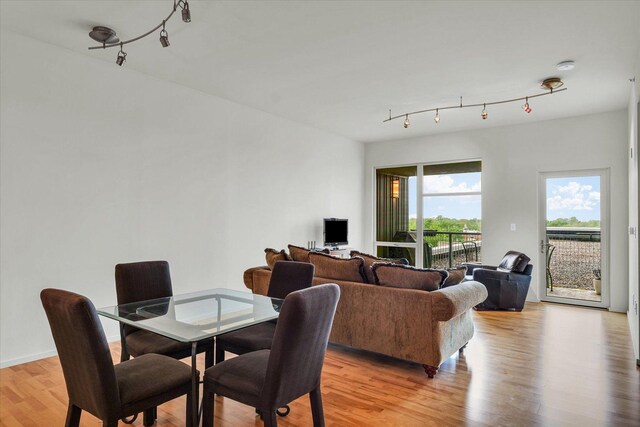dining space featuring rail lighting and light wood finished floors