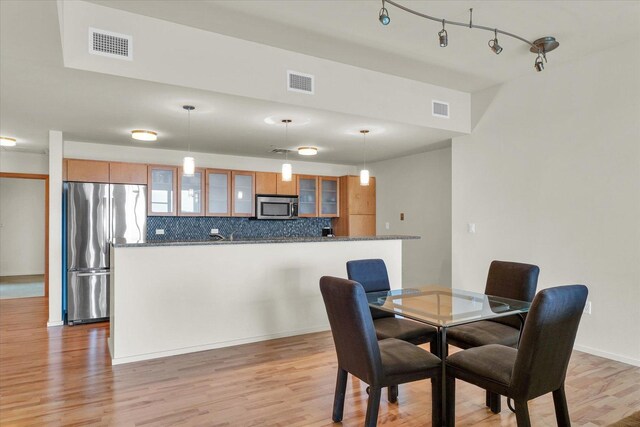 dining area featuring light wood-style flooring and baseboards