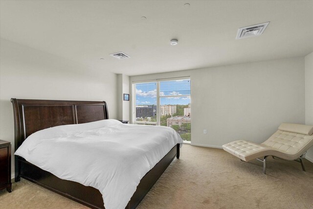 bedroom featuring access to exterior, light carpet, and baseboards