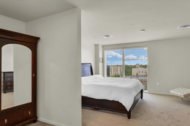 bedroom featuring light carpet, baseboards, and access to outside