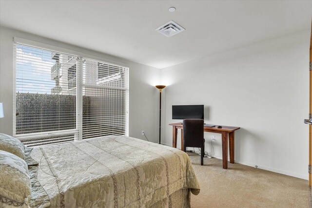 bedroom featuring light carpet, baseboards, and a desk