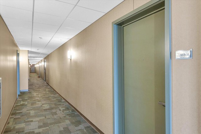 hall featuring a paneled ceiling