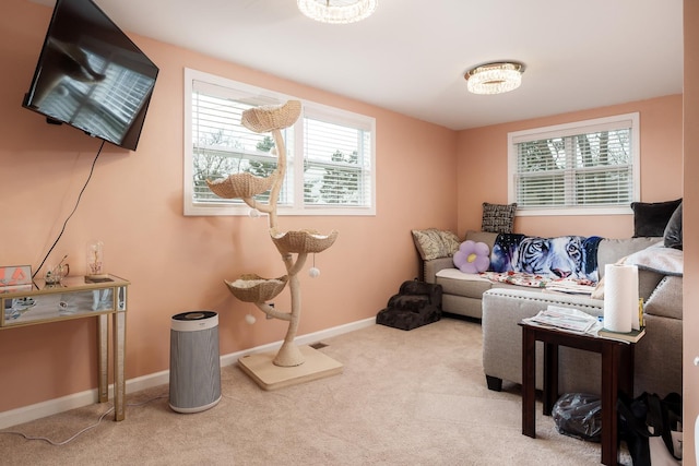 carpeted living area with a healthy amount of sunlight and baseboards