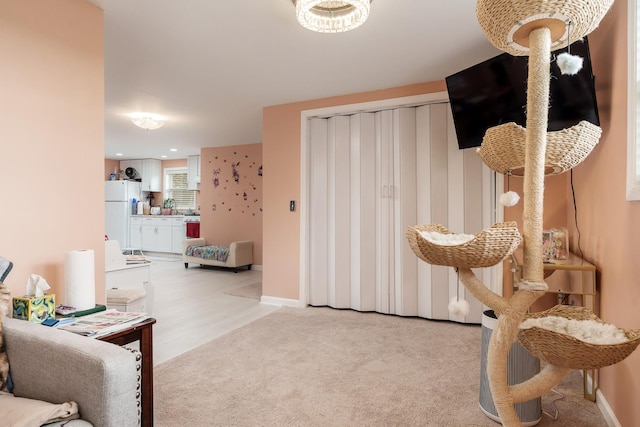 interior space with baseboards and light carpet