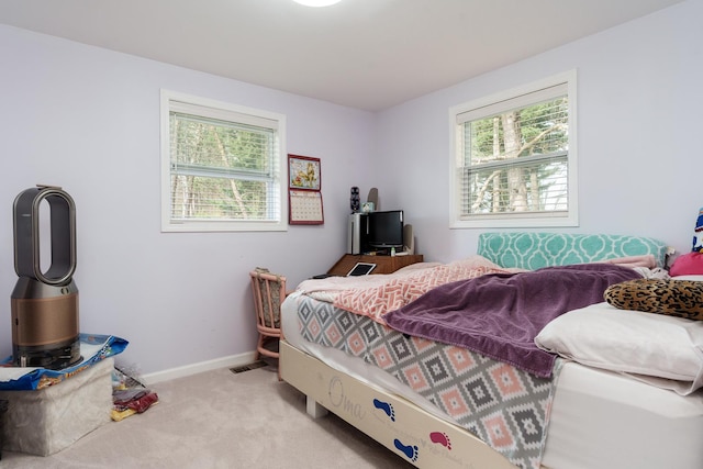 bedroom with light colored carpet and baseboards