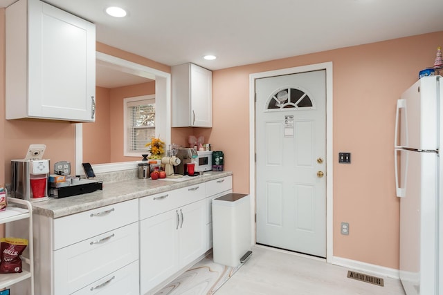 kitchen featuring visible vents, white appliances, recessed lighting, light countertops, and white cabinets