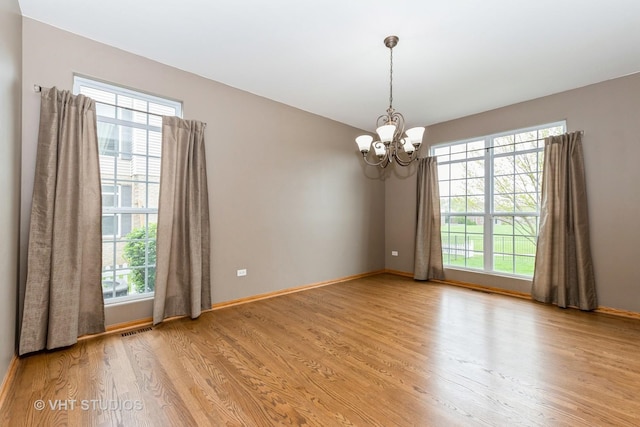 685 Veronica Ct, New Lenox, IL 60451 - unfurnished room with a chandelier, light wood-style flooring, and healthy amount of natural light