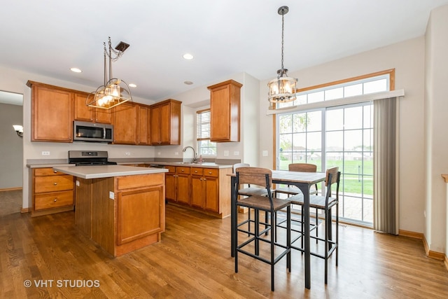 685 Veronica Ct, New Lenox, IL 60451 - kitchen featuring stainless steel appliances, a chandelier, wood finished floors, brown cabinetry, and recessed lighting
