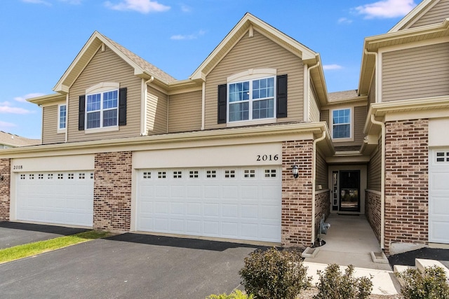 view of front of property featuring brick siding and a garage