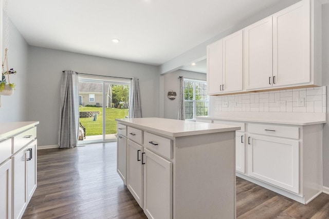 kitchen featuring dark wood-style flooring, tasteful backsplash, recessed lighting, light countertops, and a center island