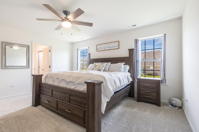 bedroom with light colored carpet, baseboards, and ceiling fan