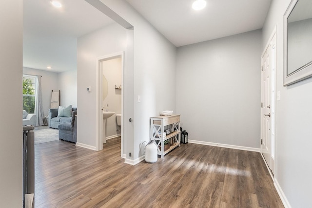 hall with wood finished floors, baseboards, and recessed lighting