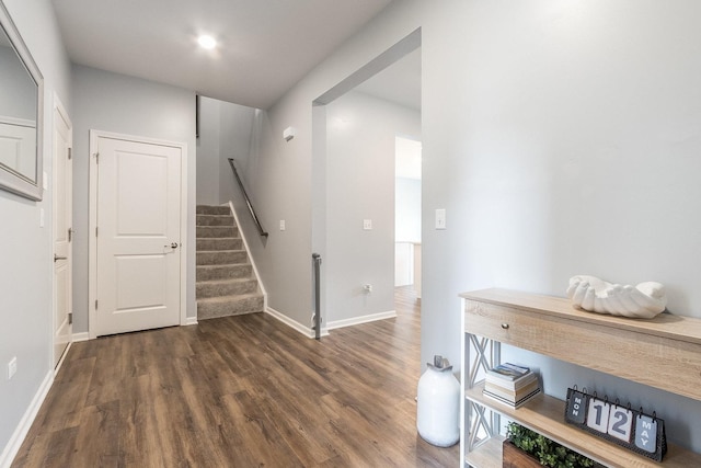foyer with wood finished floors, baseboards, and stairs