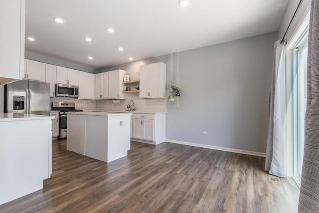 kitchen with stainless steel appliances, a sink, open shelves, light countertops, and dark wood-style flooring
