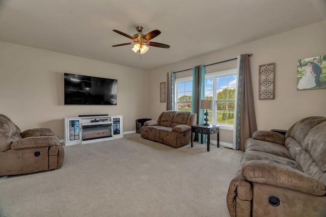 living room featuring ceiling fan, light carpet, and baseboards