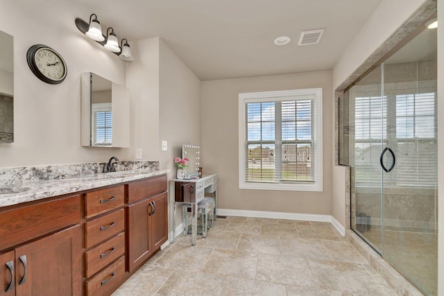 full bathroom with vanity, baseboards, a stall shower, and visible vents