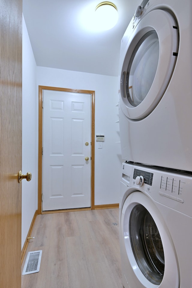 3244 Foxridge Ct, Woodridge, IL 60517 - laundry area with stacked washing machine and dryer, light wood-style flooring, and baseboards