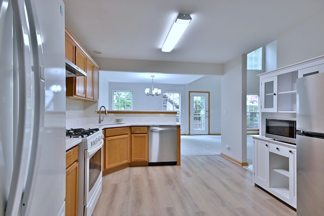 3244 Foxridge Ct, Woodridge, IL 60517 - kitchen with appliances with stainless steel finishes, a peninsula, a sink, a chandelier, and light wood-type flooring