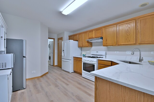 3244 Foxridge Ct, Woodridge, IL 60517 - kitchen with white appliances, a sink, estacked washer and dryer, under cabinet range hood, and light wood finished floors
