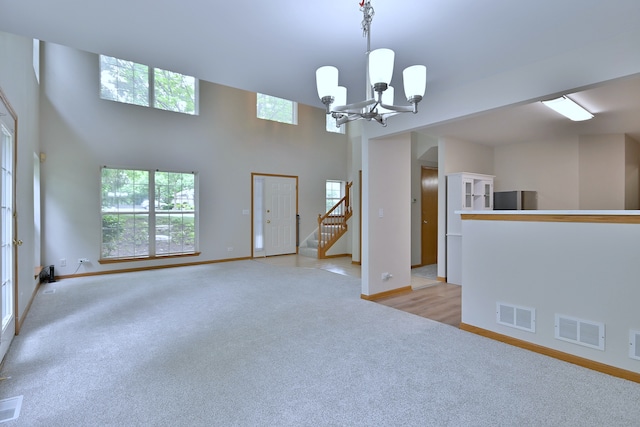 3244 Foxridge Ct, Woodridge, IL 60517 - unfurnished room with light carpet, a chandelier, baseboards, a towering ceiling, and stairway