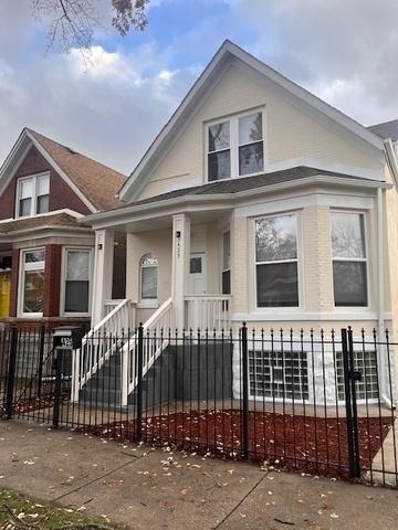 bungalow-style house with a fenced front yard and stucco siding