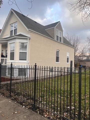 view of side of property with a lawn, stucco siding, and fence private yard