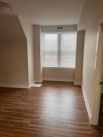 bonus room with baseboards, wood finished floors, and visible vents