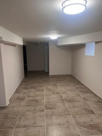 finished basement featuring tile patterned flooring and baseboards