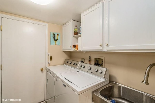 clothes washing area with cabinet space, separate washer and dryer, and a sink