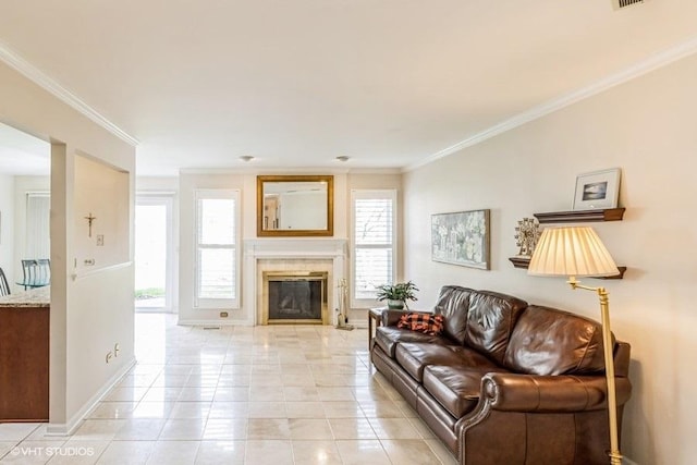 living area with crown molding, visible vents, baseboards, a tile fireplace, and light tile patterned floors