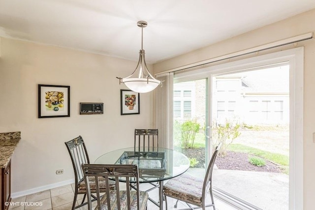 dining area with light tile patterned flooring and baseboards