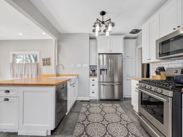 303 Anthony St, Glen Ellyn, IL 60137 - kitchen with appliances with stainless steel finishes, wood counters, a sink, a peninsula, and decorative backsplash
