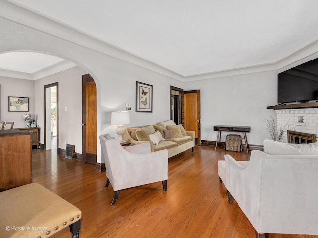 303 Anthony St, Glen Ellyn, IL 60137 - living area with arched walkways, wood finished floors, a fireplace, and baseboards