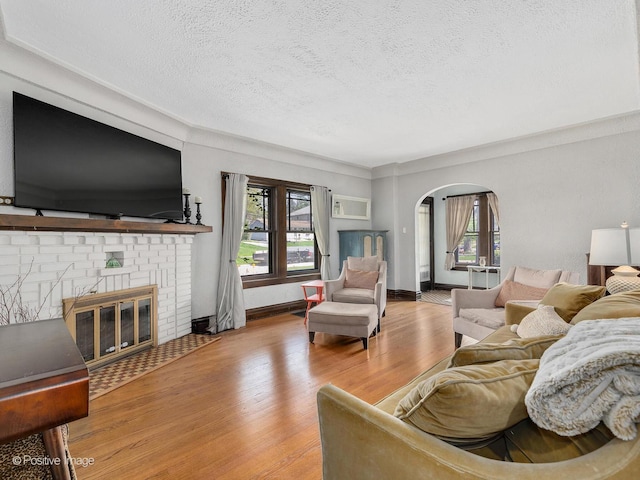 303 Anthony St, Glen Ellyn, IL 60137 - living area featuring a textured ceiling, plenty of natural light, arched walkways, wood finished floors, and a fireplace