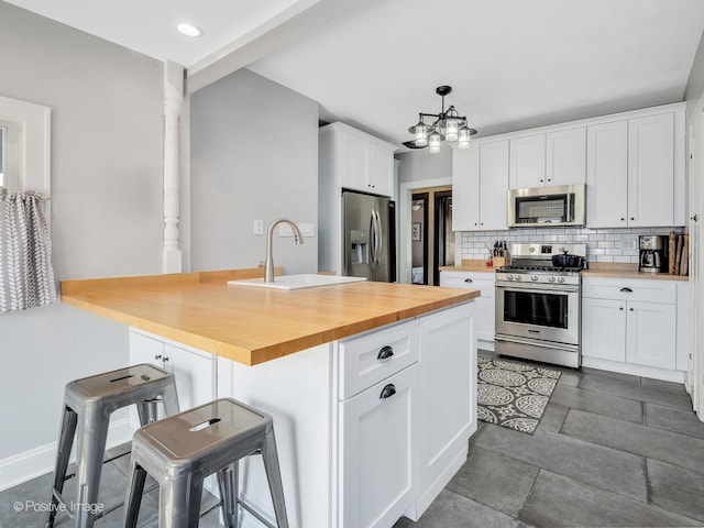 303 Anthony St, Glen Ellyn, IL 60137 - kitchen with stainless steel appliances, butcher block countertops, tasteful backsplash, a sink, and white cabinets