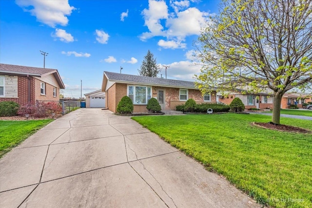 ranch-style home featuring a detached garage, a front lawn, and brick siding