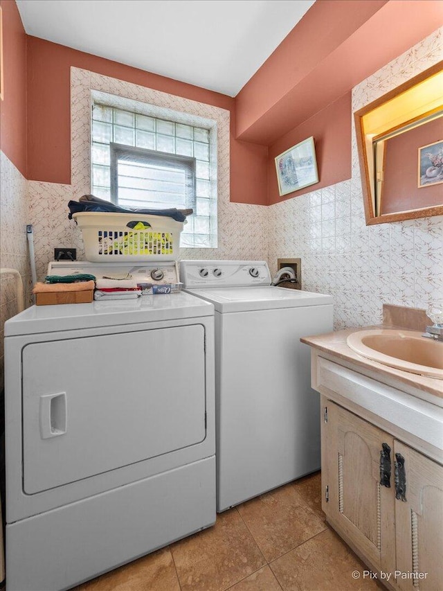 laundry area with a sink, light tile patterned flooring, cabinet space, and washing machine and clothes dryer
