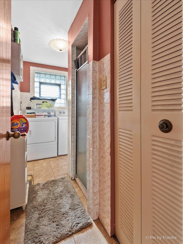 full bathroom with tile patterned floors, a stall shower, and independent washer and dryer