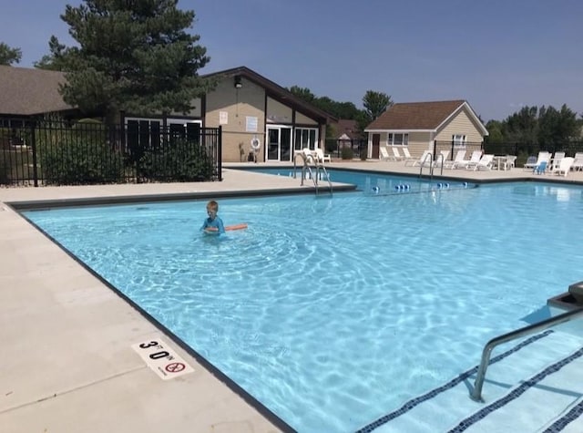 pool featuring fence and a patio
