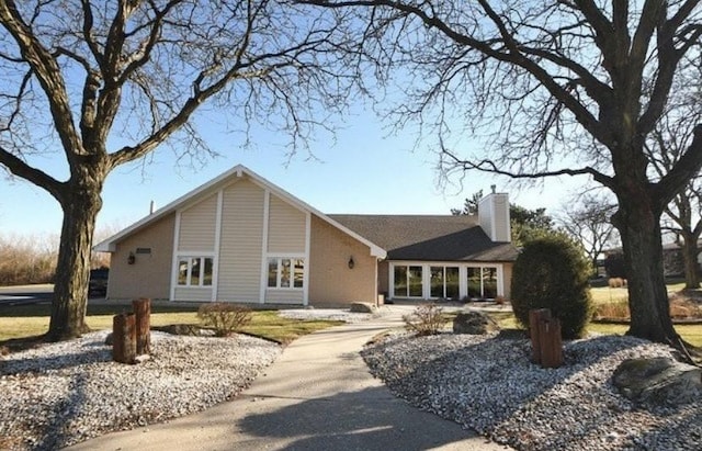 single story home featuring brick siding and a chimney