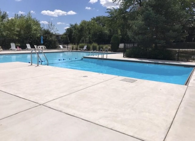 pool with a patio and fence