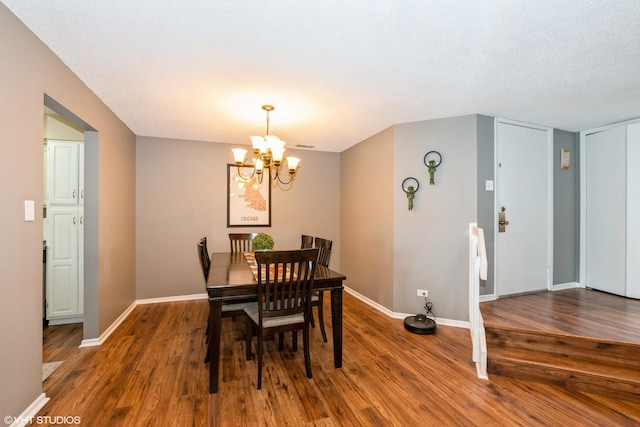 dining room with an inviting chandelier, baseboards, and wood finished floors