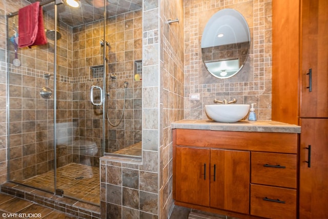 full bath featuring vanity, tile walls, and a shower stall