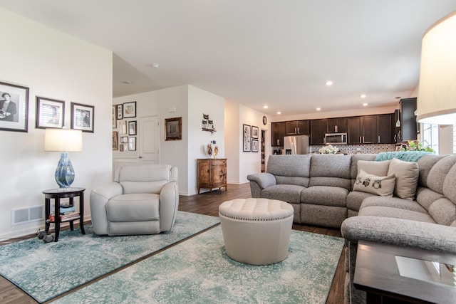 living area featuring baseboards, recessed lighting, wood finished floors, and visible vents
